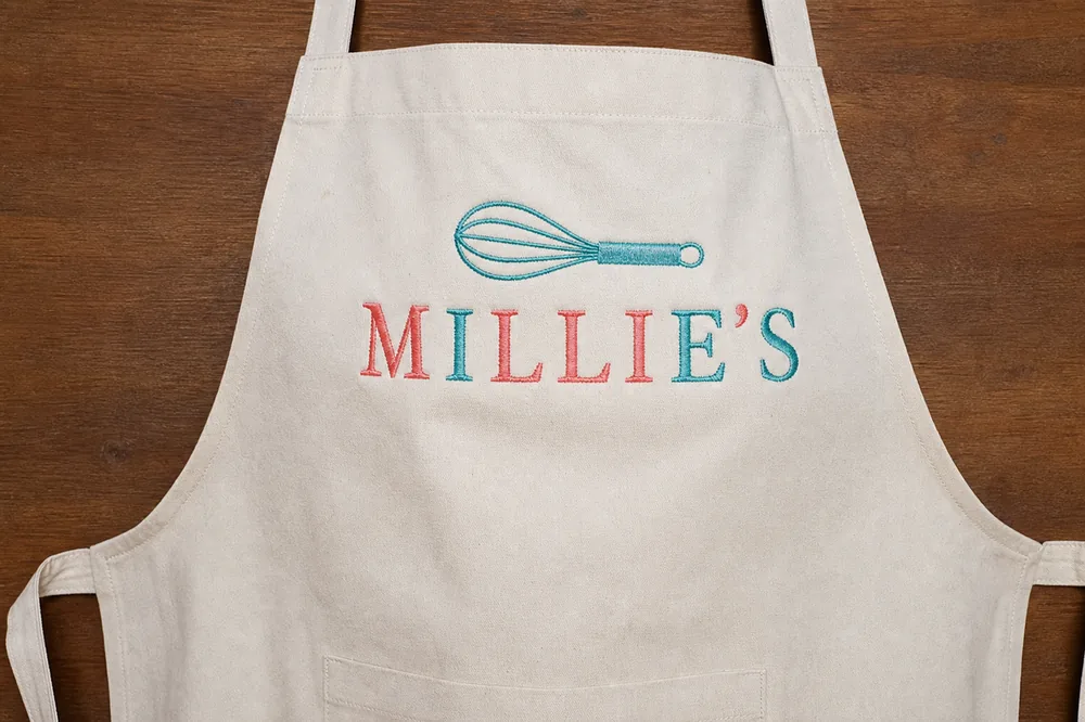 Machine-embroidered bakery name on a kitchen apron